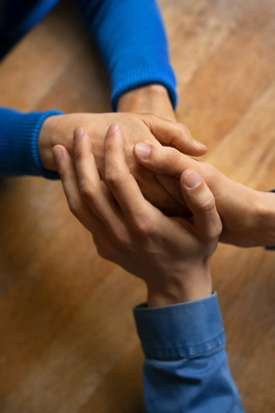 Dos personas cogidas de las manos en señal de apoyo